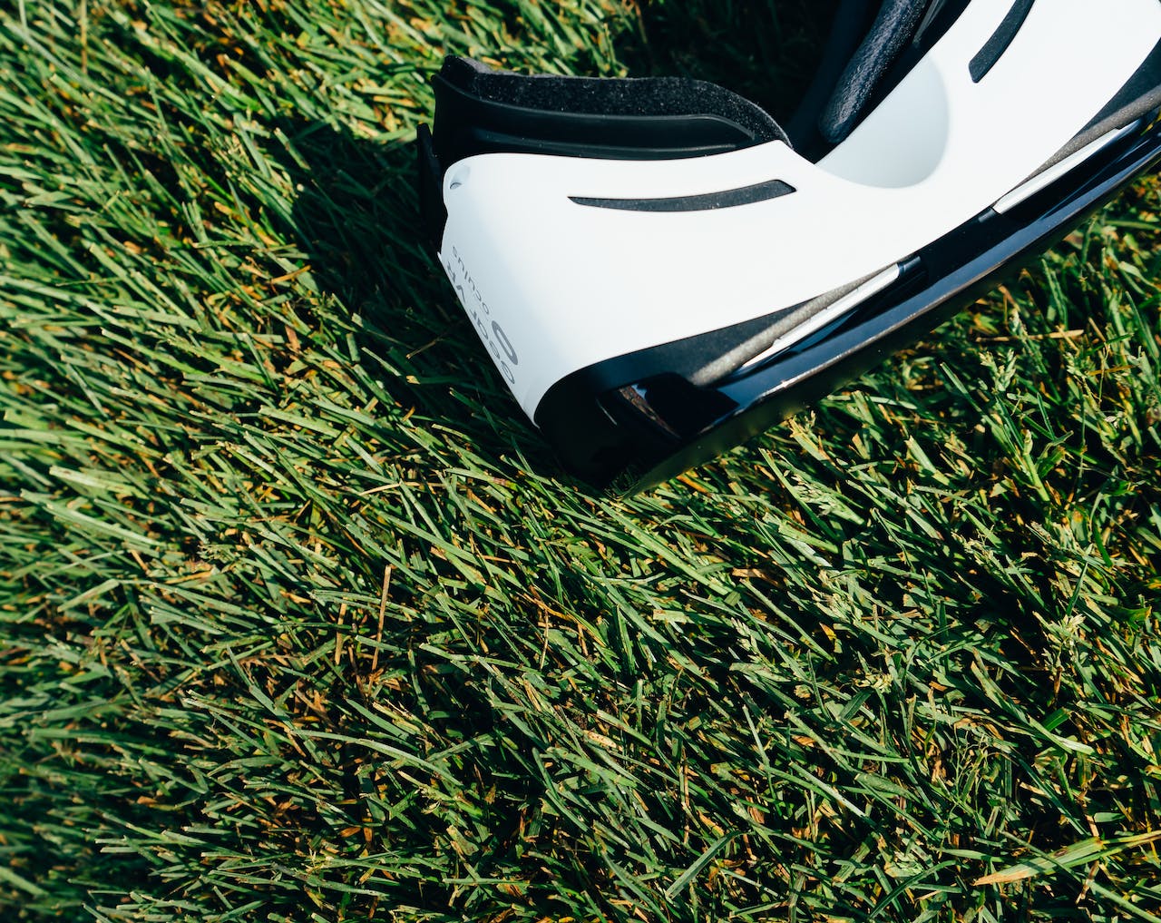 White and Black Vr Headset on Green Grass